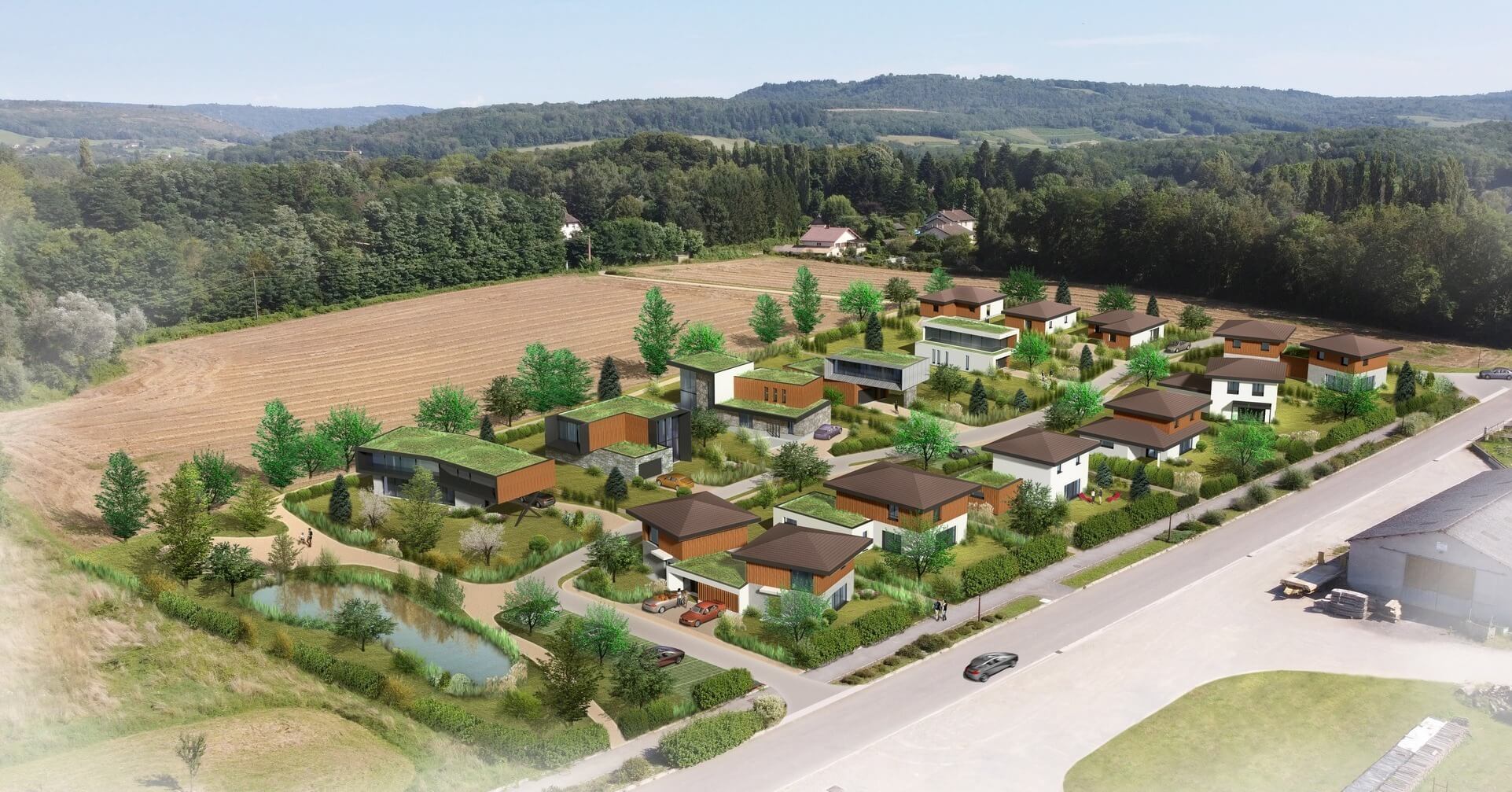 Lotissement moderne avec maisons et étang en campagne.