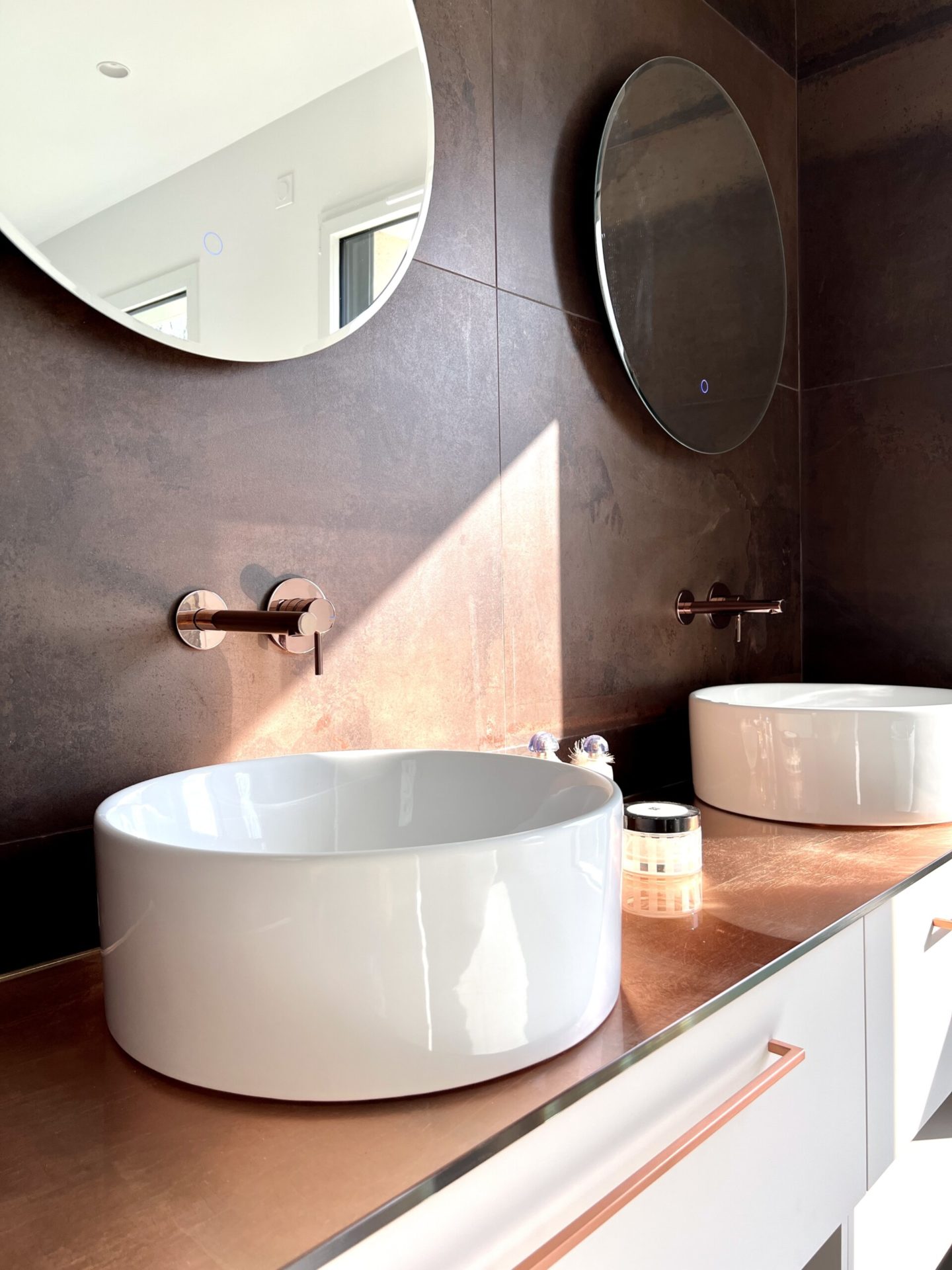 Salle de bain moderne avec lavabos blancs et miroirs.