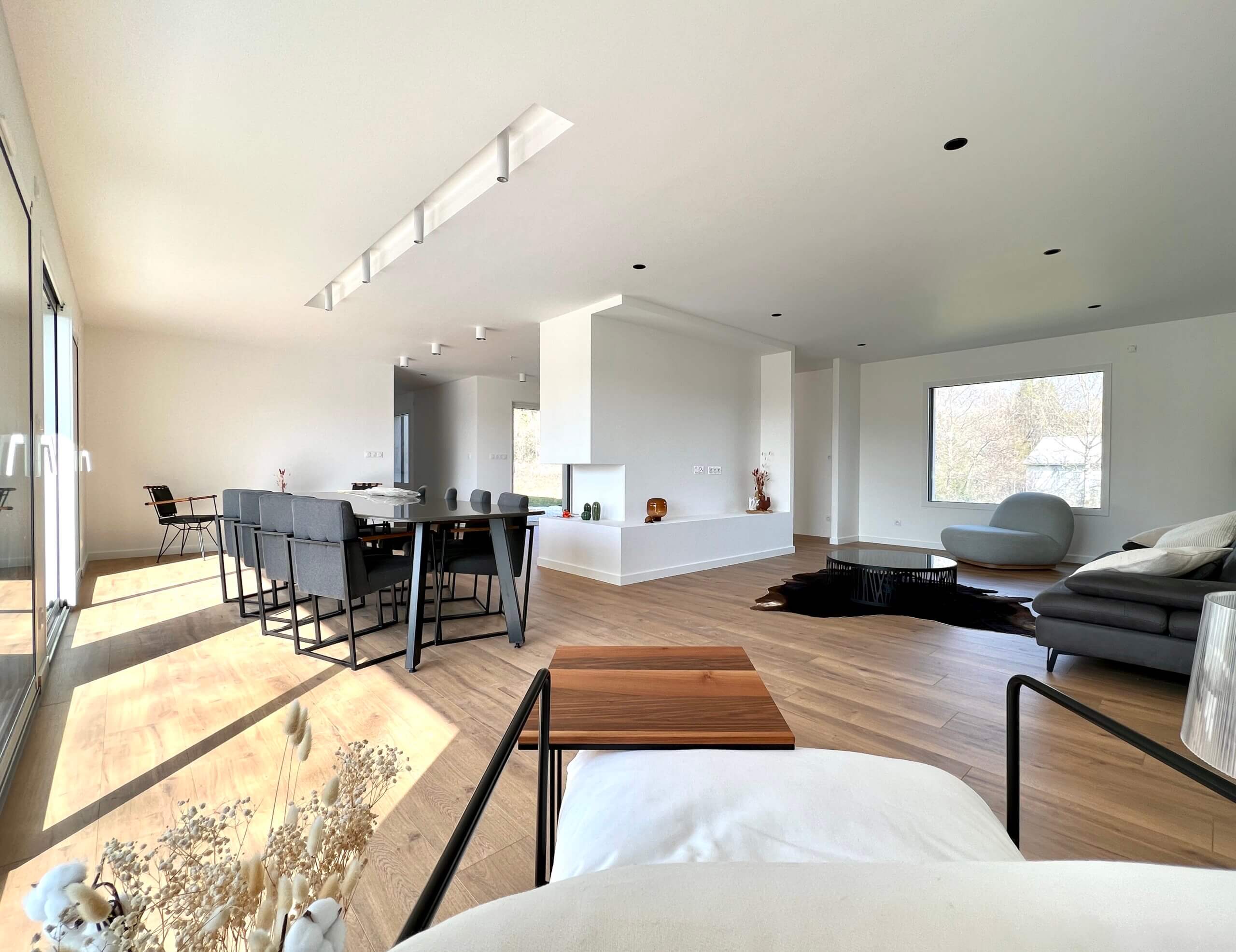 Intérieur moderne et épuré avec salon, salle à manger et cuisine.